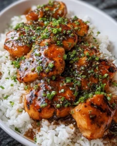 Maple Chicken served on coconut rice topped with herbs and spices