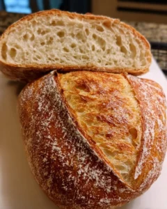 Soft & golden sourdough loaf fresh from the oven, showcasing its crispy crust and airy interior.