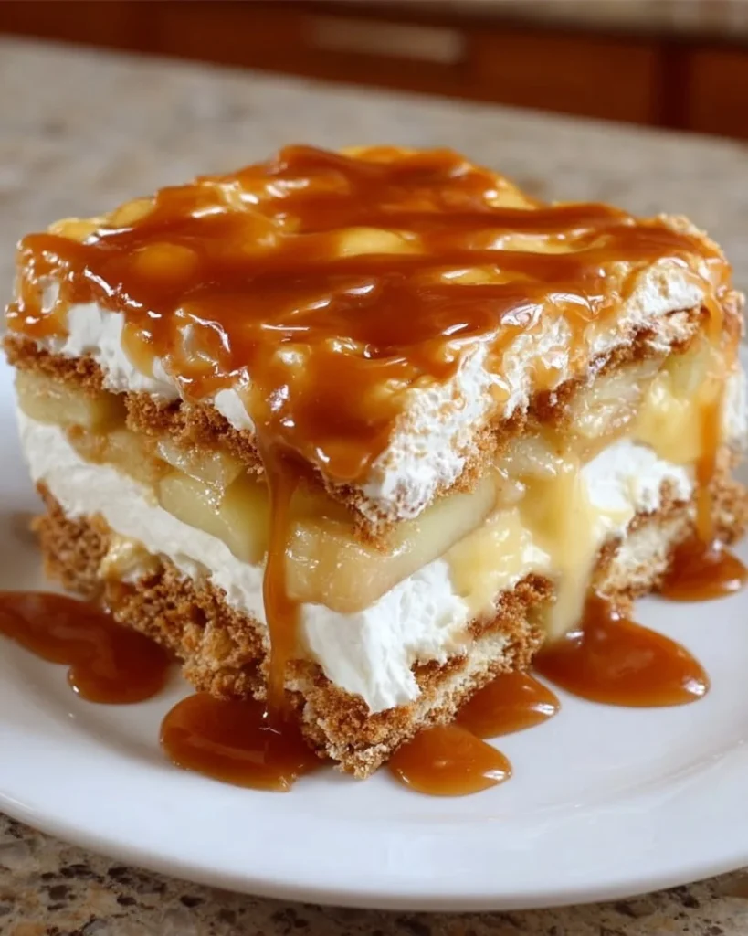 Caramel Apple Éclair Cake topped with caramel sauce and fresh apple slices