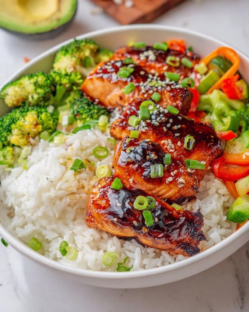 Delicious Teriyaki glazed salmon rice bowl with vegetables and chopsticks.