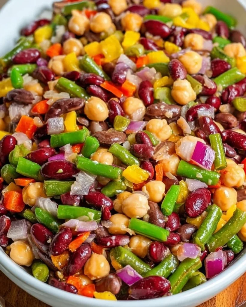 Colorful simple 5 bean salad in a bowl with fresh vegetables and dressing