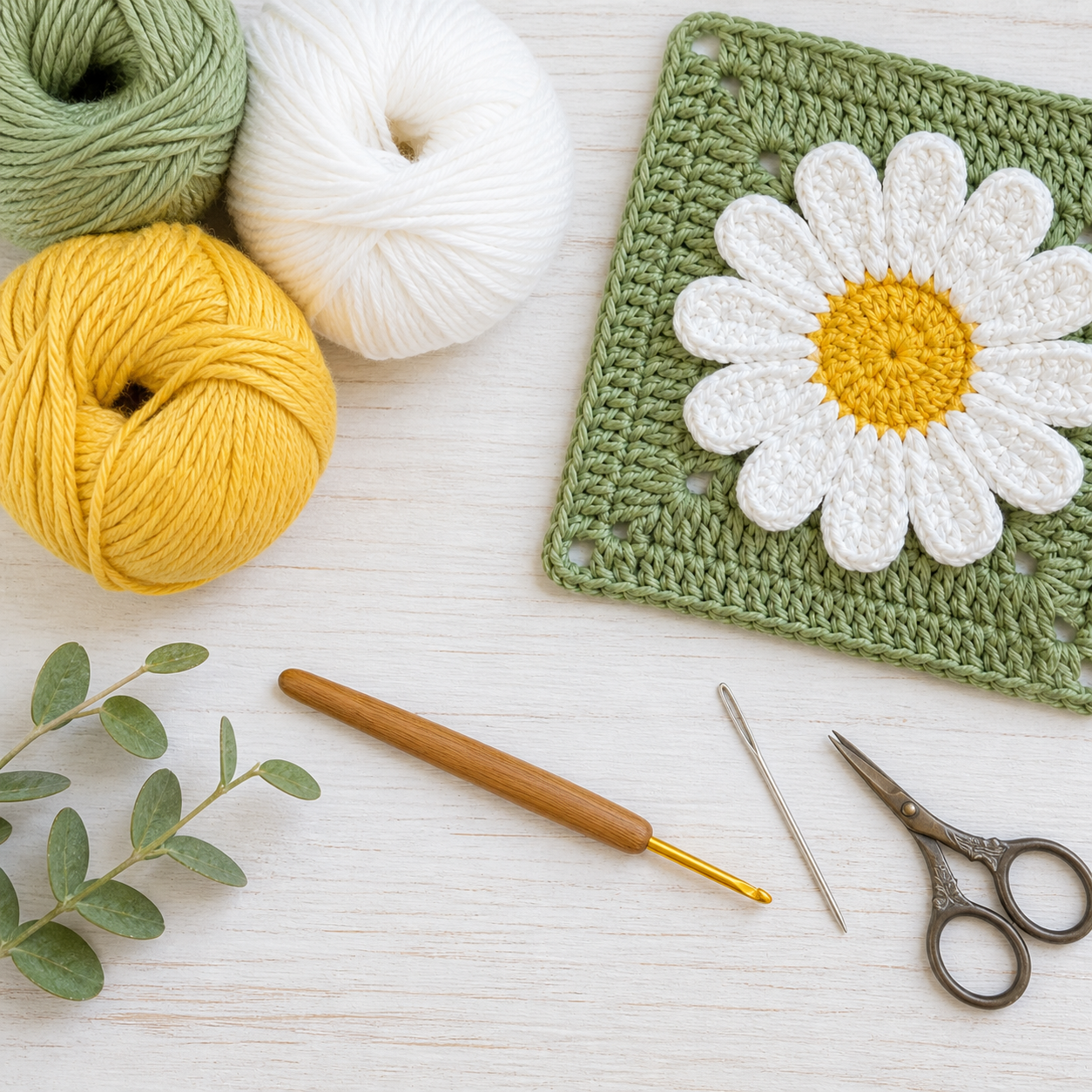 Yellow, white, and green cotton yarn with hook and daisy square materials