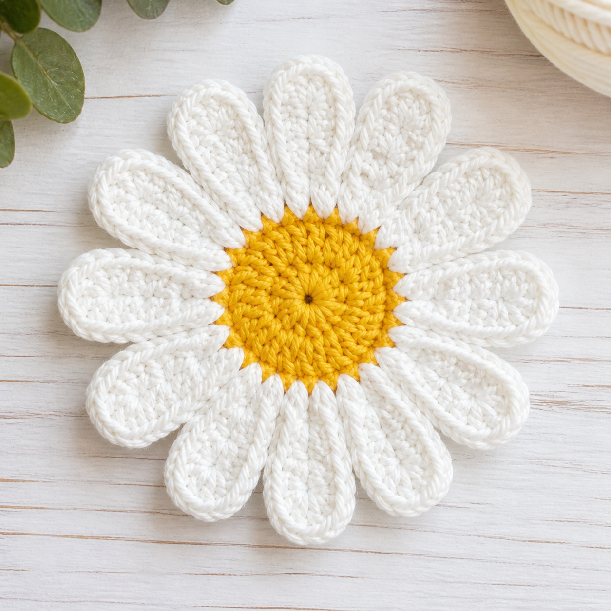 Twelve white crochet petals completed around the yellow center