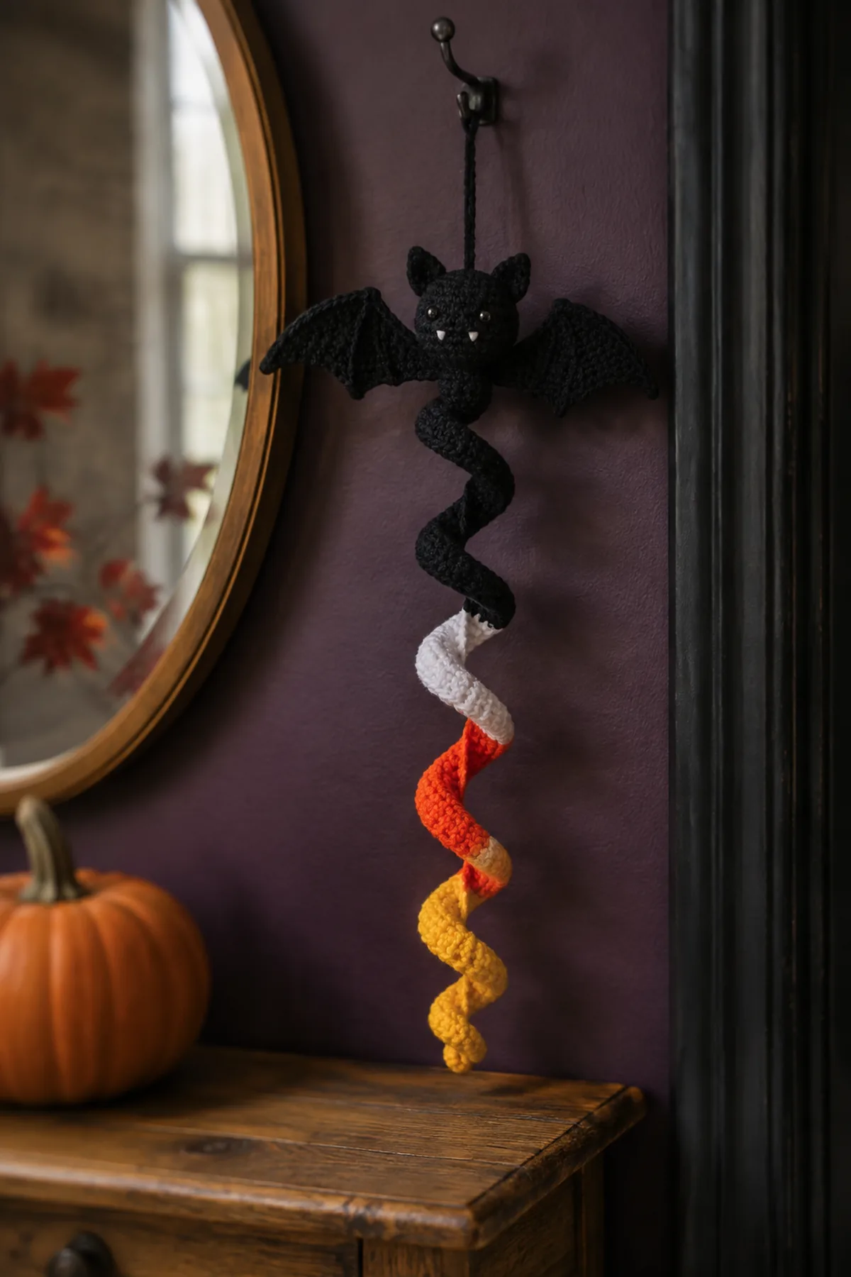 Finished Halloween crochet spiral decoration displayed near a pumpkin.