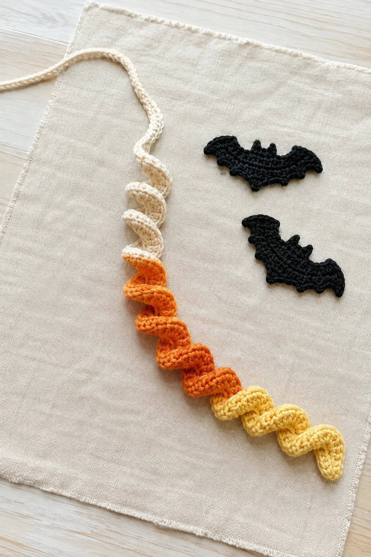 Striped foundation chain beginning to curl into a Halloween crochet spiral.