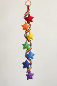 Finished Rainbow Stars Crochet Spiral hanging with a rainbow corkscrew ribbon, seven colorful stuffed stars, and a natural wooden ring
