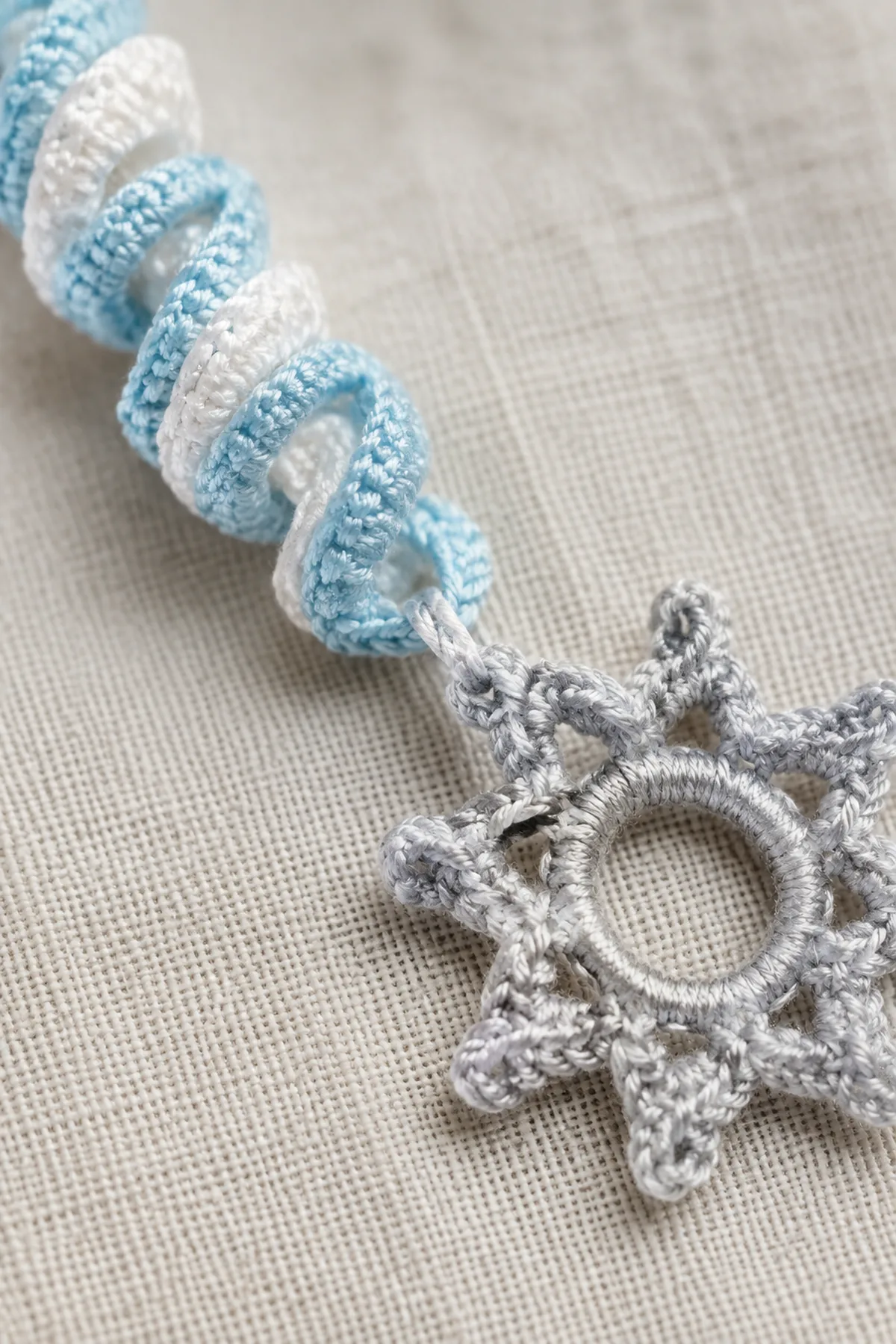 Close view of a winter crochet corkscrew secured to the snowflake ring.