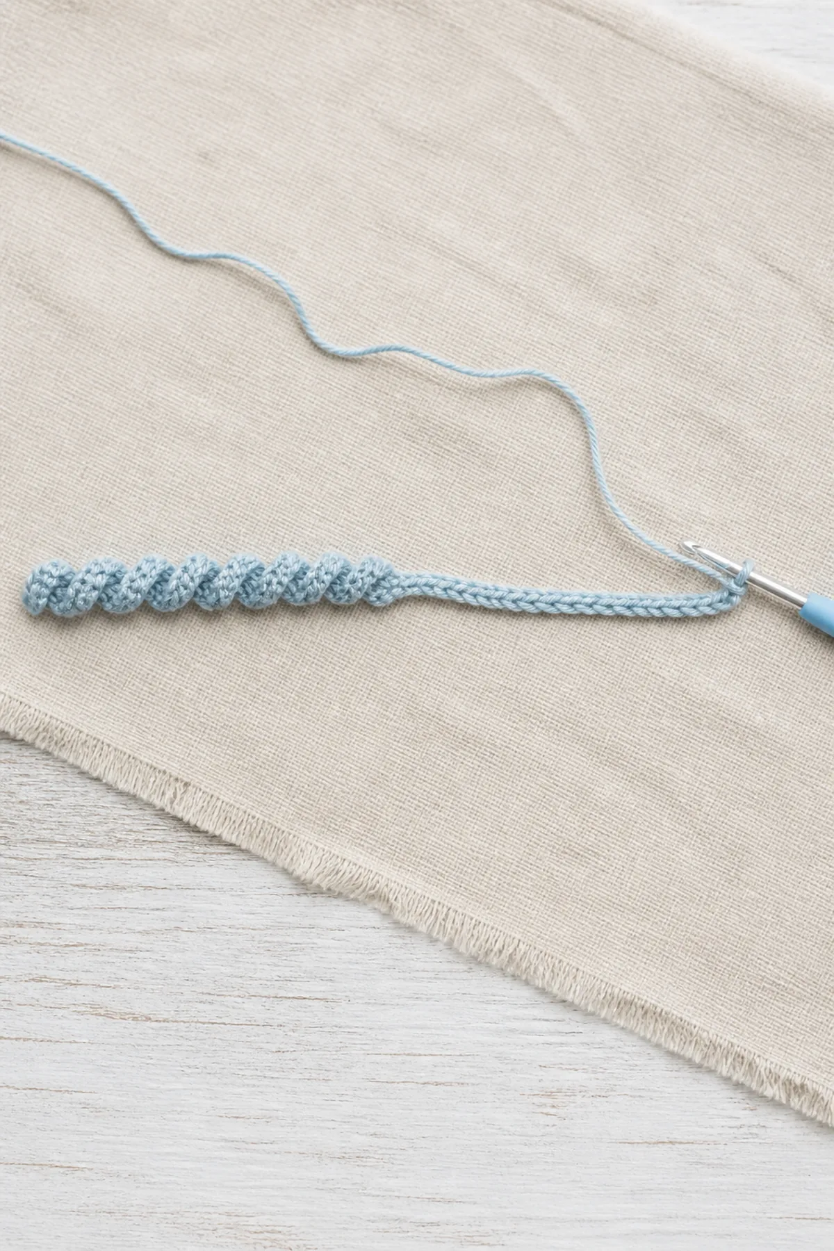 Icy blue foundation chain changing into a tight single-crochet corkscrew.